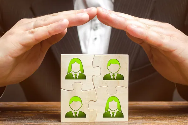¿Merece la pena un seguro de decesos?: unas manos protegen la silueta de papel de una familia