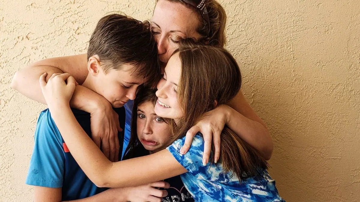 Una madre resguarda a sus tres hijos, una imagen sobre el precio del seguro de decesos en Asturias