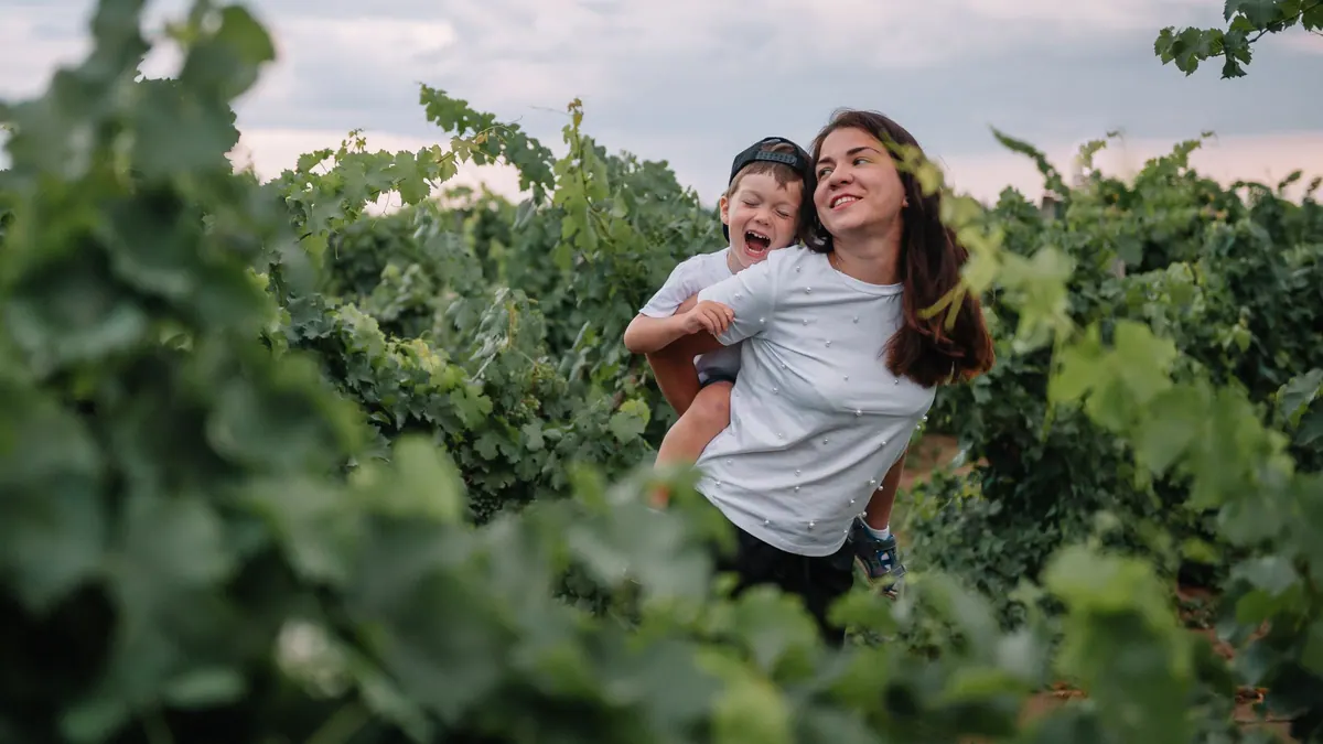 Una madre abraza a su hijo en un viñedo, una imagen para la guía sobre qué cubre el seguro de decesos
