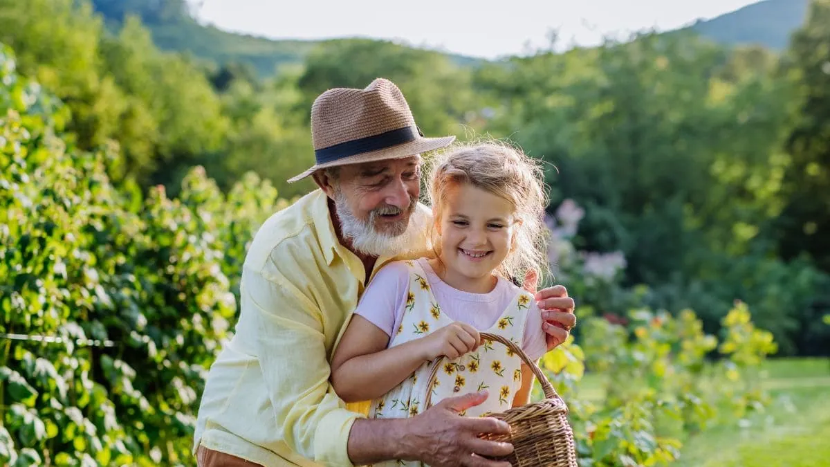 Un abuelo y su nieta comparten un momento en el jardín, una imagen del seguro de decesos en Seseña